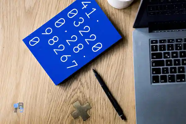 تصویر تعدادی عدد روی کاغذ کنار لپ تاپ